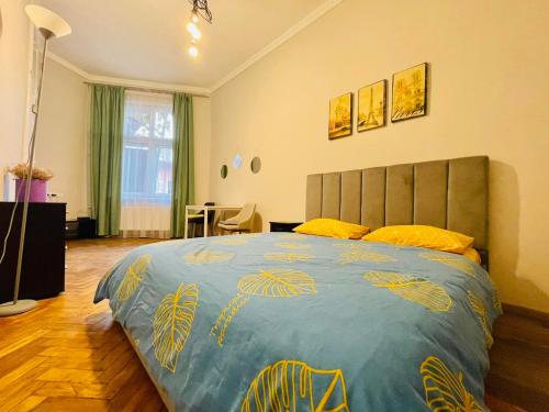 1 dormitorio con 1 cama grande con almohadas amarillas en Джерельна 25, апартаменти в центрі з двома ізольованими спальнями, en Leópolis