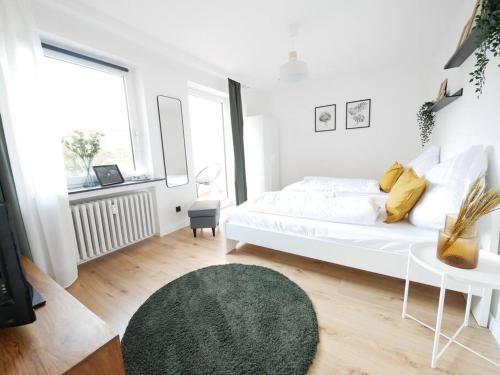 - une chambre blanche avec un lit blanc et un tapis vert dans l'établissement 69 m², zentral, Balkon, stilvoll, à Osnabrück