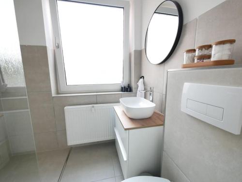 a white bathroom with a sink and a mirror at 69 m², zentral, Balkon, stilvoll in Osnabrück