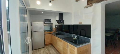 une cuisine avec un réfrigérateur en acier inoxydable et des armoires en bois dans l'établissement Villa A Volta, à Urtaca