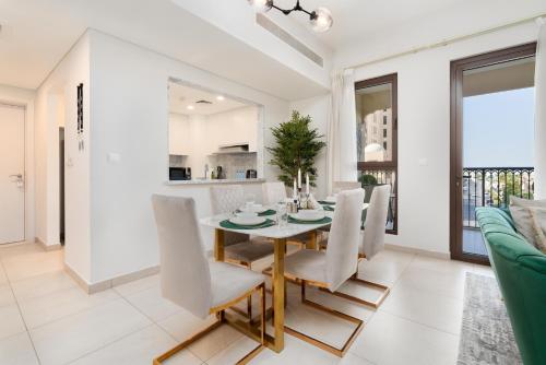 a dining room and living room with a table and chairs at Ultimate Stay / Burj Al Arab View / Brand New / Amazing Pool with a View / Perfect Holiday / Madinat Jumeirah / 2 BDR in Dubai