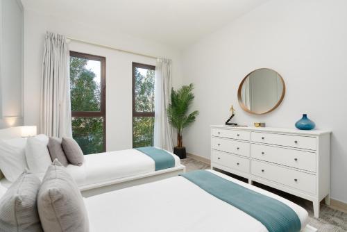 a white bedroom with a white dresser and a mirror at Ultimate Stay / Burj Al Arab View / Brand New / Amazing Pool with a View / Perfect Holiday / Madinat Jumeirah / 2 BDR in Dubai