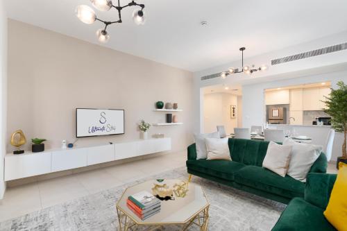 a living room with a green couch and a table at Ultimate Stay / Burj Al Arab View / Brand New / Amazing Pool with a View / Perfect Holiday / Madinat Jumeirah / 2 BDR in Dubai