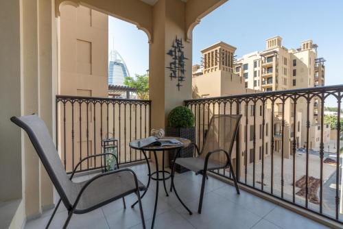 a balcony with chairs and a table and a view of a city at Ultimate Stay / Burj Al Arab View / Brand New / Amazing Pool with a View / Perfect Holiday / Madinat Jumeirah / 2 BDR in Dubai