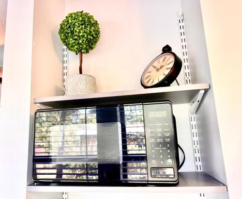 a clock on a shelf above a microwave at Upgraded, Stylish & Comfy 1 Bedroom/1 Bath Studio in Payson