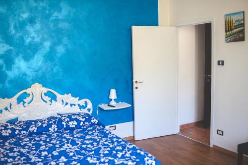 a bedroom with a bed and a blue wall at Agriturismo La Collina Toscana in Pieve a Maiano