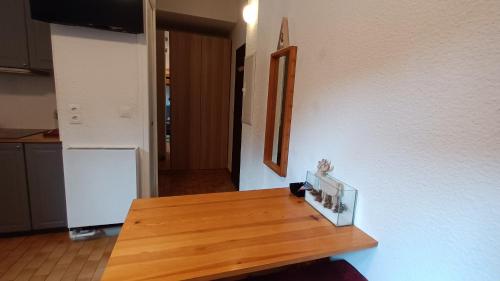 eine Küche mit einem Holztisch und einem Kühlschrank in der Unterkunft Le Lautaret in La Salle Les Alpes
