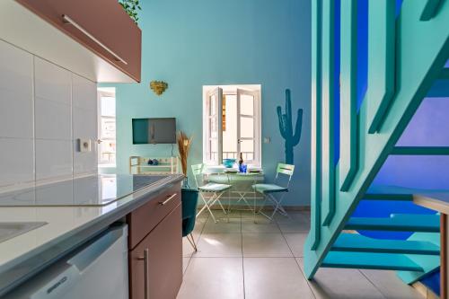 une cuisine aux murs bleus et une salle à manger dans l'établissement Le Rêve Bleu Majorelle - Duplex sur les toits - Une Nuit à Nîmes, à Nîmes