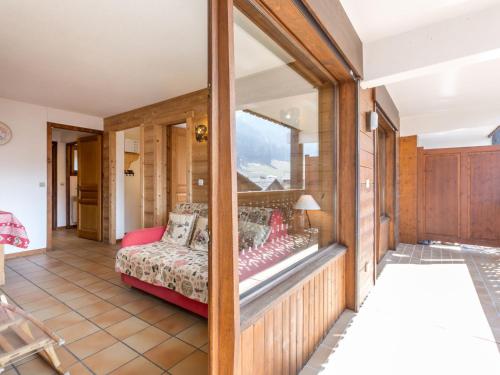 Cette chambre comprend un lit et une fenêtre en verre. dans l'établissement Appartement La Clusaz, 2 pièces, 5 personnes - FR-1-304-84, à La Clusaz