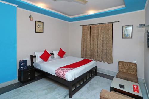 a bedroom with a bed with red pillows at OYO 13161 Apni Havali Hotel & Restaurant in Rāmpura
