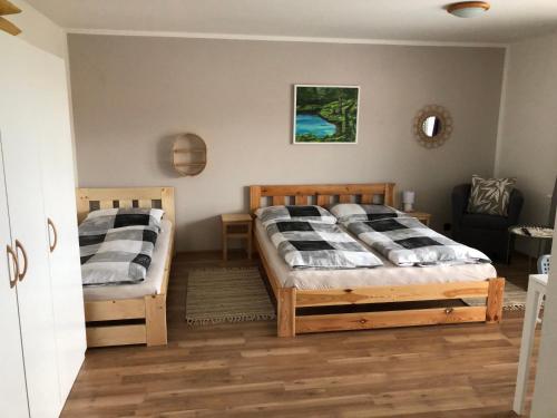 1 dormitorio con 2 camas y 1 silla en Ubytování u Malinků, en Přítluky