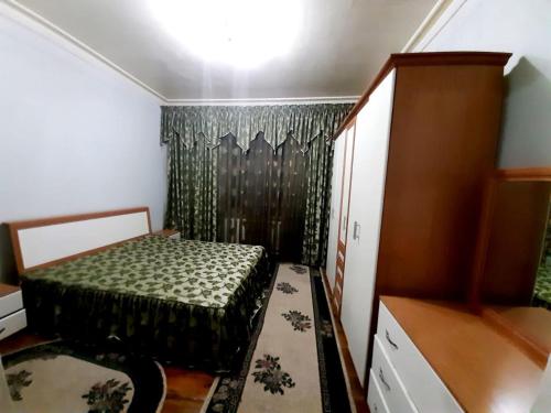 a small bedroom with a bed and a dresser at Апартаменты Registan in Samarkand