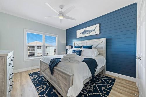 a blue bedroom with a bed and a blue wall at Luxury 5BR Gulf Shores Oceanfront +Pool &Amenities in Gulf Shores