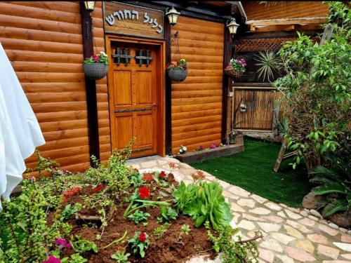 a house with a wooden door and a garden at The Pearl of the Golan - Pnina BaGolan in Had Nes