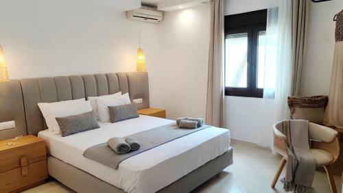 1 dormitorio con 1 cama y 1 silla en Mina's House Beachfront Apartments, en Nikiti