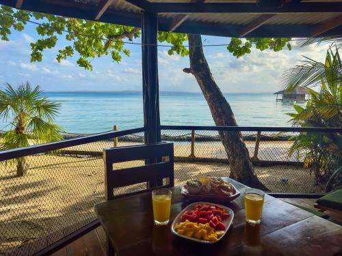 a table with a tray of food and drinks on the beach at Casa Cayuco Eco-Adventure Lodge in Bocas del Toro
