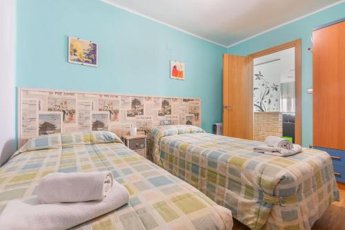 two beds in a room with blue walls at Vivienda Turística Portal de Teruel in Teruel