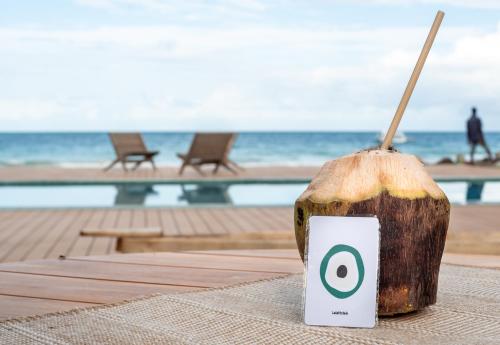 a cup of coffee sitting on a table near the beach at LalaGalu - Beachfront EcoCabins in Diani Beach