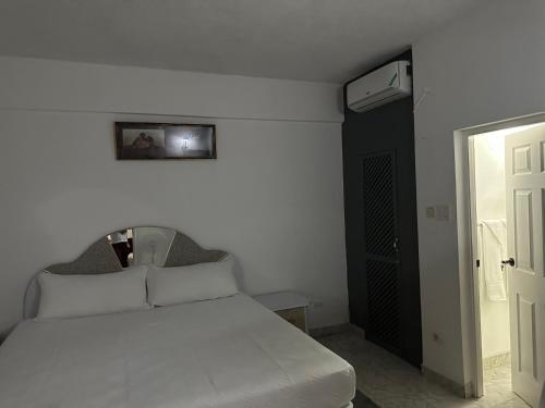 a bedroom with a white bed and a black door at Remarkable 1-Bed Apartment in Montego Bay in Montego Bay