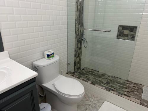 a white bathroom with a toilet and a shower at Remarkable 1-Bed Apartment in Montego Bay in Montego Bay