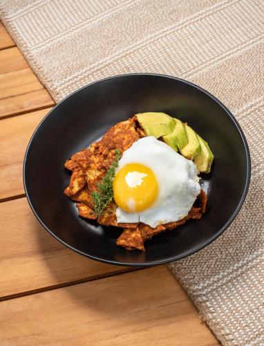 a plate of food with an egg on top at LalaGalu - Beachfront EcoCabins in Diani Beach