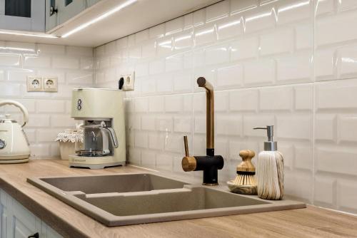 eine Küchentheke mit Spüle und Kaffeemaschine in der Unterkunft Alfa home in Iraklio