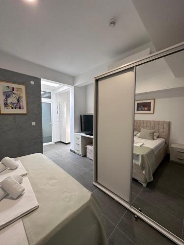 sypialnia z lustrem, łóżkiem i telewizorem w obiekcie Hotel MonteNino w Barze