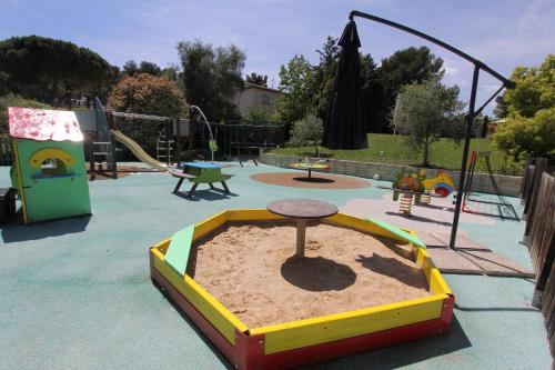a playground with a sand pit in a park at "AU HAVRE DE PAIX" 5 étoiles Prestige jacuzzi, hammam, sauna, PISCINE chauffée Mougins Cannes Grasse in Mougins