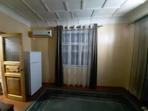 um quarto com um frigorífico e uma janela em Place to stay em Samarkand