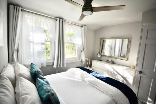a bedroom with a bed and two windows at Private Summer Rental Beach House with a 30ft Boat Dock in Southampton