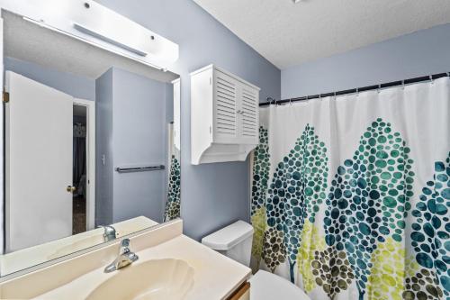 a bathroom with a sink and a shower curtain at Daly Vibes in Rodanthe