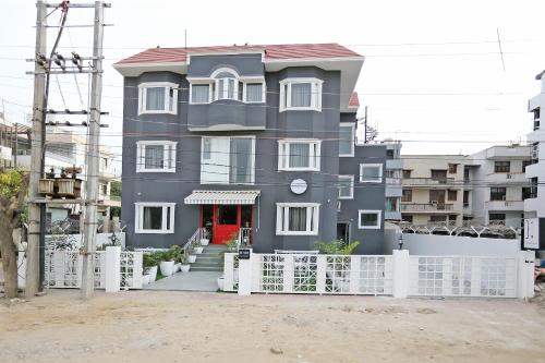 una casa gris con una cerca blanca delante de ella en OYO Townhouse 17 Huda City Center Near Leisure Valley Park en Gurgaon