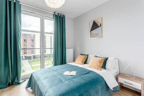 a bedroom with a bed and a large window at Praga Residence Premium in Warsaw