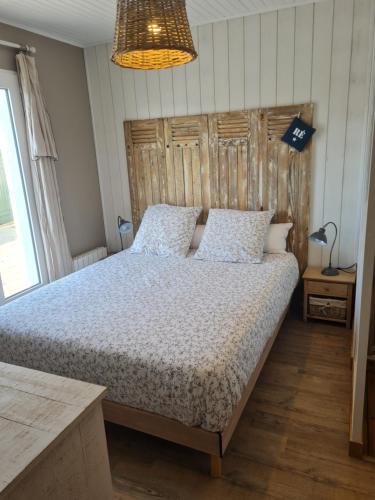 a bedroom with a bed with a wooden headboard at Villa la Ferlandiere in Sainte-Marie-de-Ré