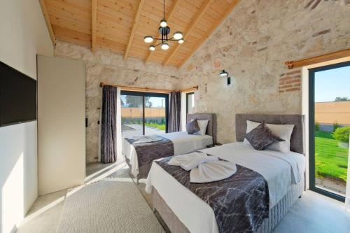 2 Betten in einem Zimmer mit einem großen Fenster in der Unterkunft Ader villa 2 in Fethiye