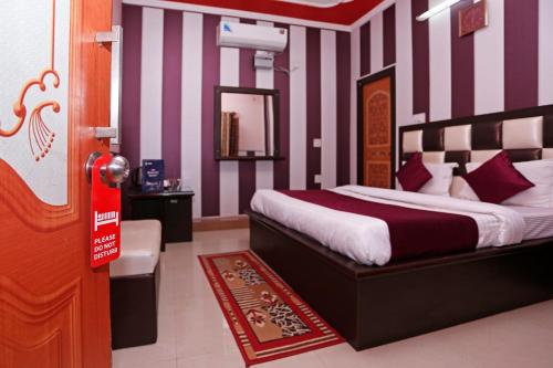 a bedroom with a bed with purple and white stripes at Mehfil Hotel in Jawālāpur