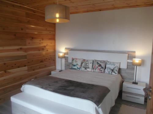 a bedroom with a white bed with wooden walls at Casa do Morro in Sintra