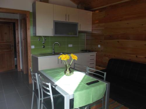 uma cozinha com uma mesa com um vaso de flores em Casa do Morro em Sintra