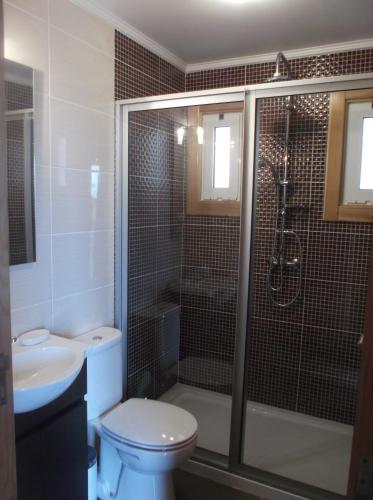 a bathroom with a shower and a toilet and a sink at Casa do Morro in Sintra
