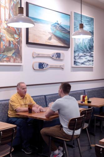 two men sitting at a table in a restaurant at Treasure Bay Casino & Hotel-Adults Age 21 and Above in Biloxi