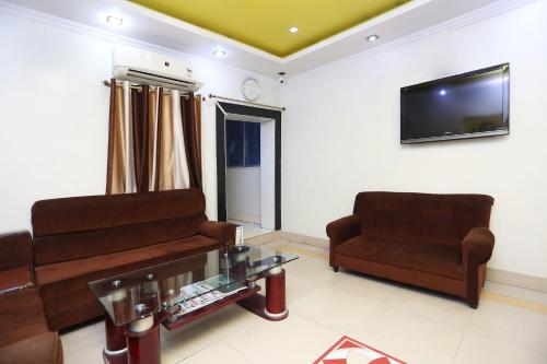 uma sala de estar com um sofá e uma cadeira em New Mega Palace em Bankipur