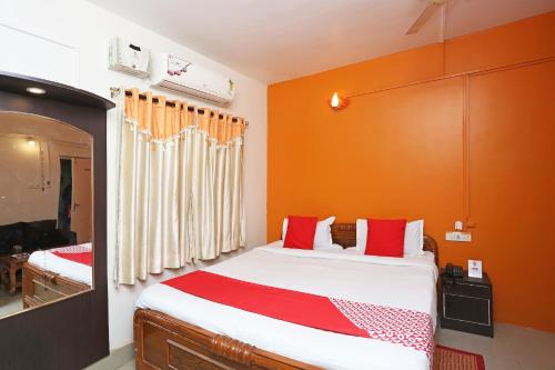 a bedroom with a large bed with red pillows at New Mega Palace in Bankipur