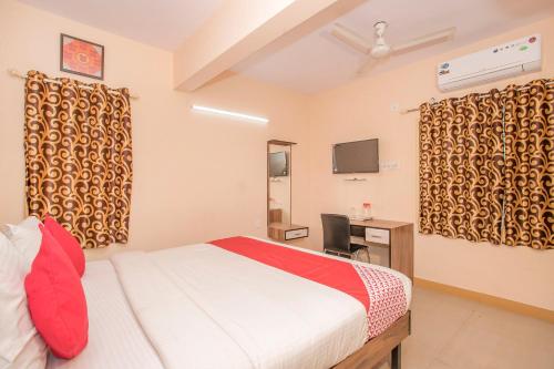 a bedroom with a bed and a desk and a television at OYO 8116 Park Inn in Bangalore