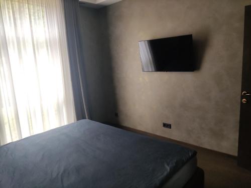 a bedroom with a bed and a television on the wall at Jelskio apartamentai in Vilnius