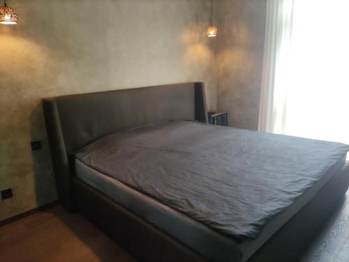 a bed sitting in a room with a window at Jelskio apartamentai in Vilnius