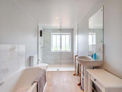 a white bathroom with a tub and a sink at The Oast - Uk43087 in Preston