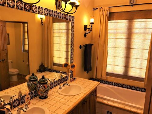 a bathroom with two sinks and a mirror and a tub at Casa Sierra by Casago in Loreto