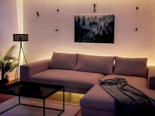 a living room with a couch and a painting on the wall at NOVA Romantic Luxus Relax Apartments mit Sauna, Nürburgring, Adenauer Forst in Adenau