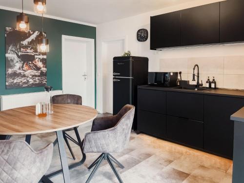 a kitchen with a table and a refrigerator at NOVA Romantic Luxus Relax Apartments mit Sauna, Nürburgring, Adenauer Forst in Adenau