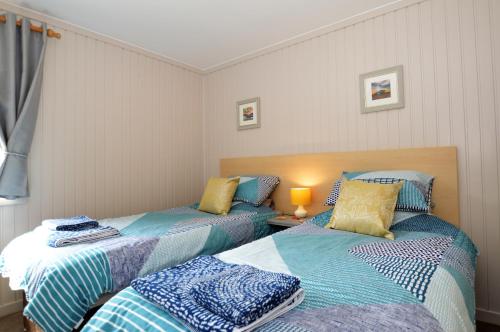 two beds sitting next to each other in a room at Blairlagan Lodge in Hunters Quay